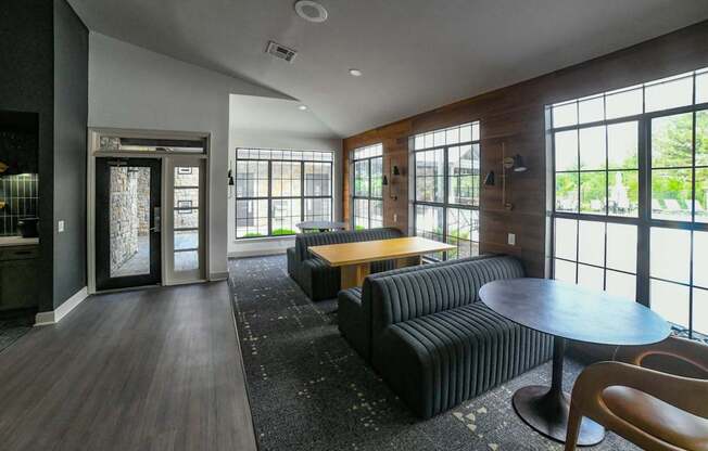 A modern living room with a black sofa and a wooden coffee table.