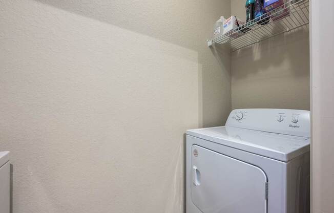A white washing machine sits in a laundry room.