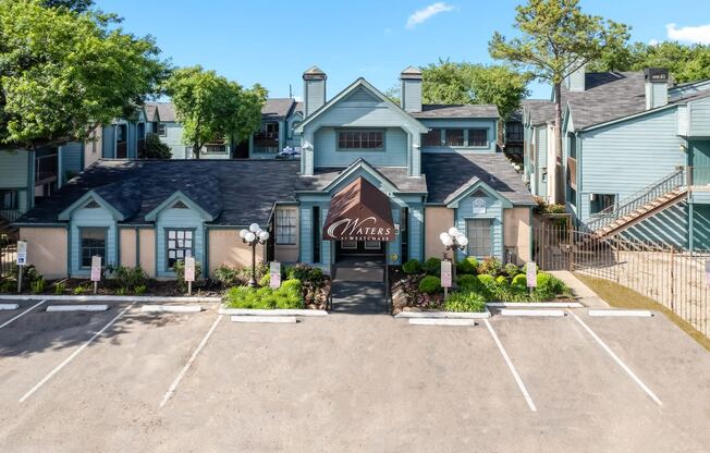 a large blue house with a driveway and a parking lot