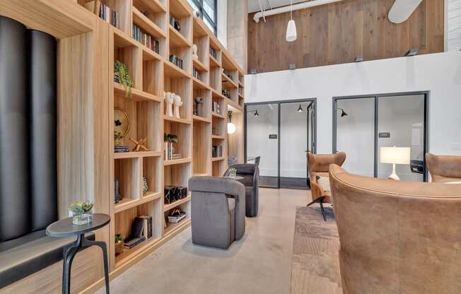 a living room with wooden shelves and couches and chairs