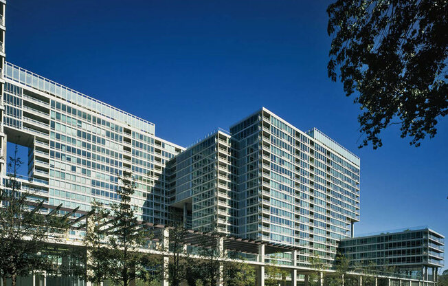 A modern glass building with a clear blue sky in the background.