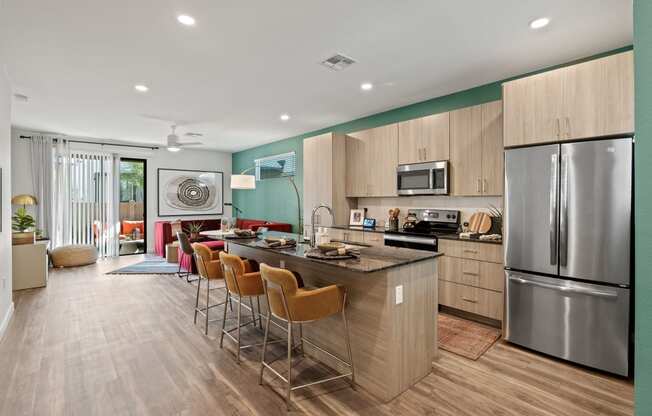 a kitchen with a large island and a stainless steel refrigerator