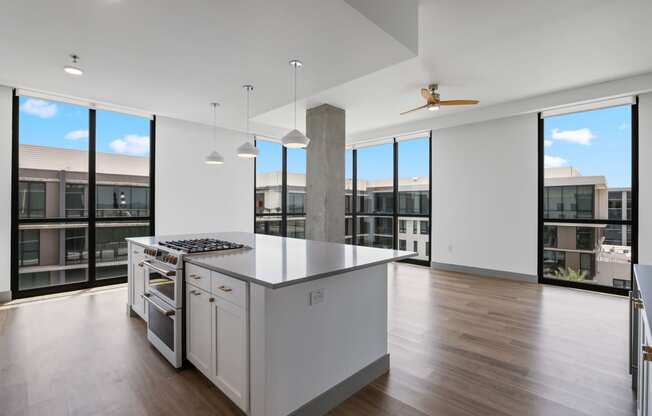 an open kitchen with a large island and a view of a building and windows