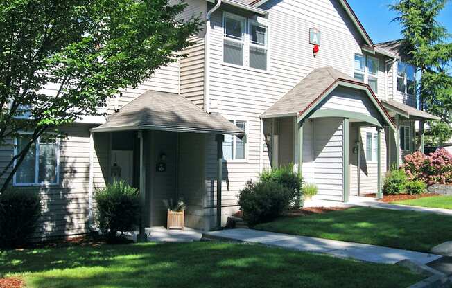 A house with a grey siding and a brown roof.