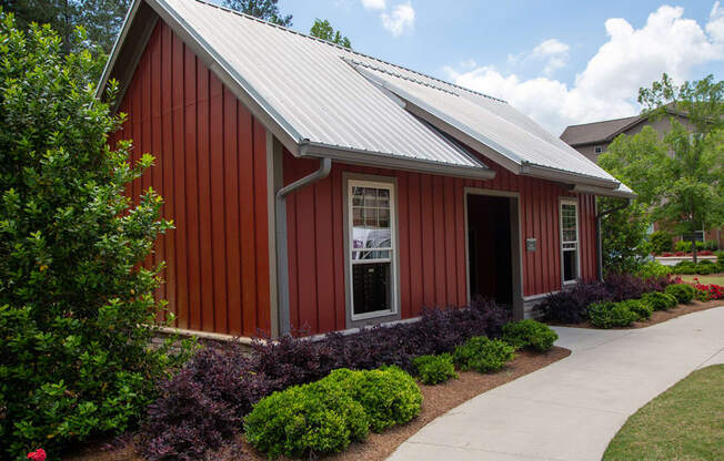 a red building with a metal roof and a sidewalk in front of it
