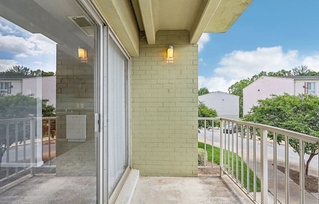 A balcony with a glass door leading to a patio.