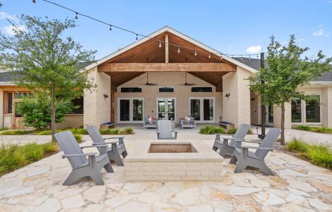 a patio with chairs and a fountain in front of a house