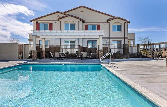 A large house with a pool in front.
