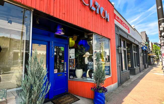 a red building with a blue door and blue potted plants