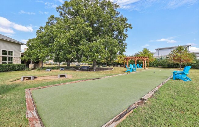 A green lawn with a red border and a blue chair.