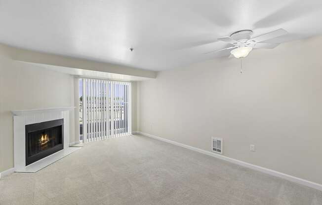 a living room with a fireplace and a ceiling fan at Casa Blanca Apartment Homes, Everett, WA