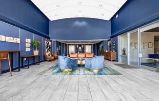 furnished lobby with high ceiling and blue wall