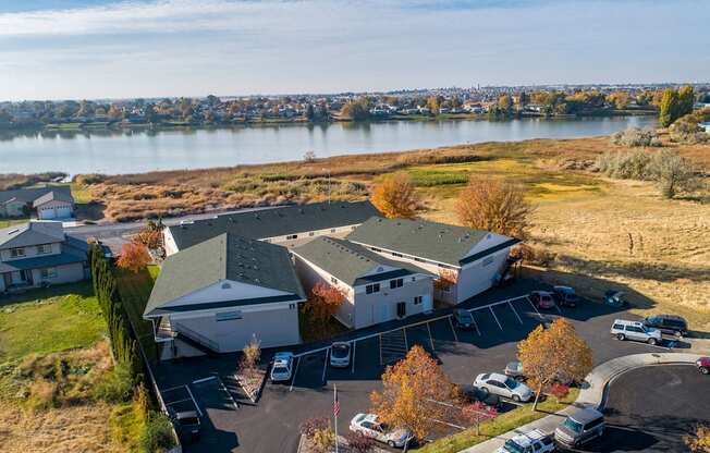 Aerial view of the community with grass fields leading to Moses Lake behind The Lakes Apartments.at The Lakes Apartments, Moses Lake