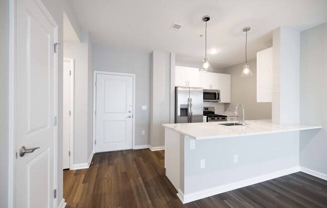 A kitchen with white cabinets and a wooden floor. at Harbor Pointe, Bayonne, New Jersey