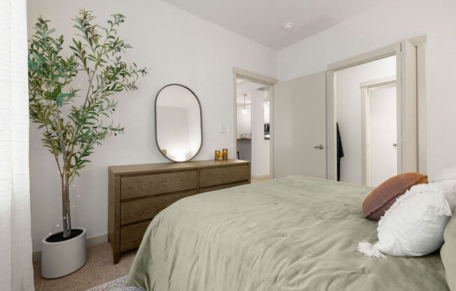 a bedroom with a bed and a potted plant