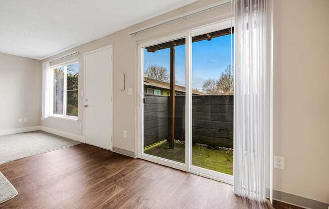A room with a sliding glass door leading to a backyard.