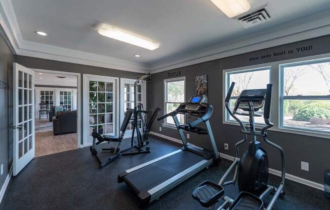 a home gym with exercise equipment and windows