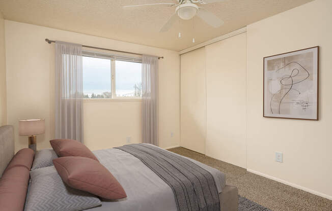 A bedroom with a large bed and a ceiling fan.