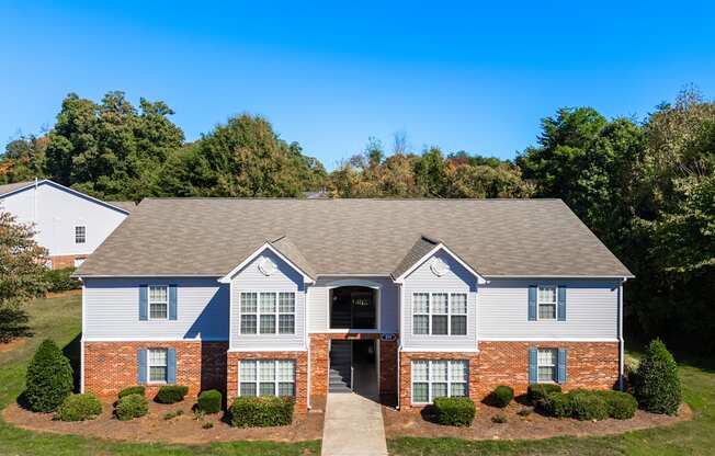 A house with a grey roof and red brick pillars.