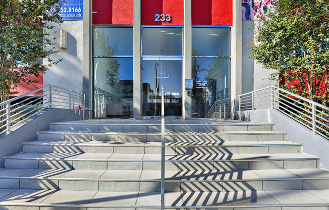 A set of concrete stairs leads to a glass door with the number 233 on it.