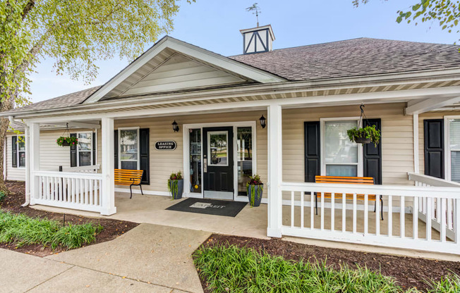 the front porch of a white house with a porch swing