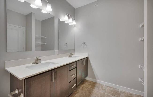 A bathroom with a sink, mirror, and lighting fixtures.