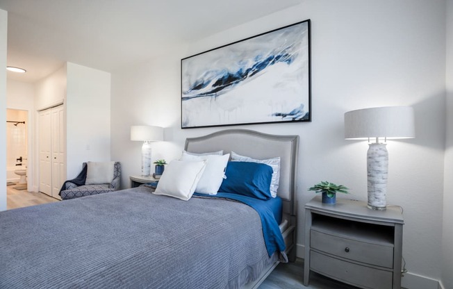 a bedroom with a large bed with blue and white pillows