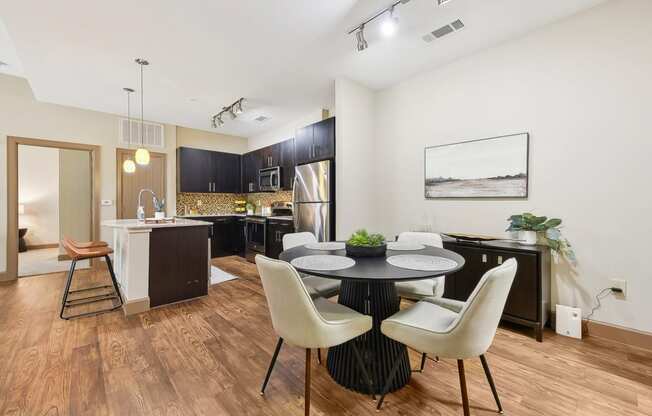 a dining room and kitchen with a table and chairs