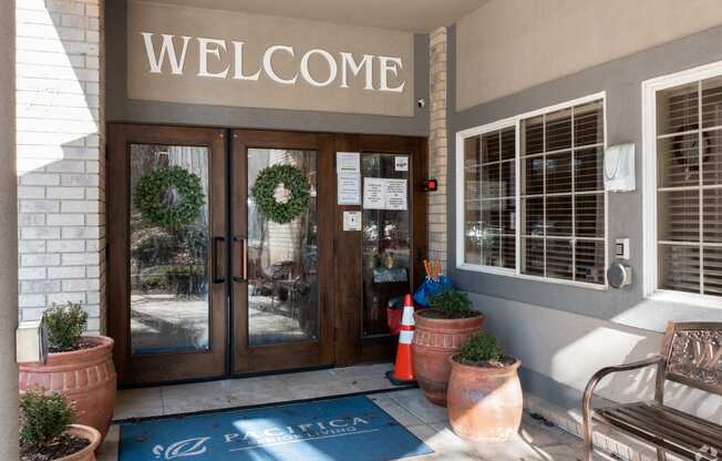 the entrance of a building with doors and a welcome sign