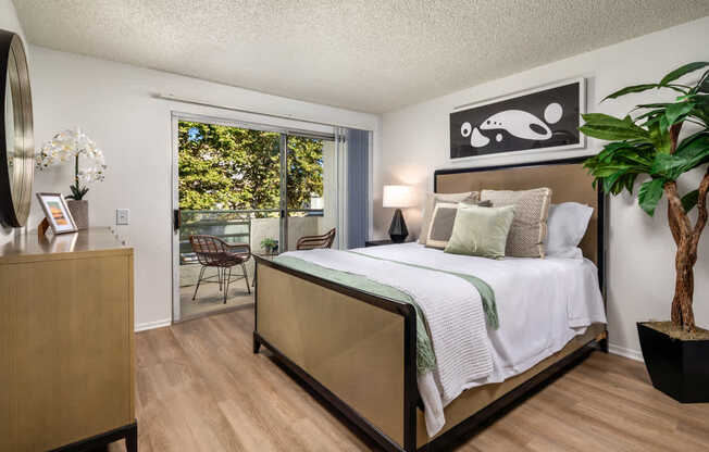 A bedroom with a large bed and a wooden dresser.