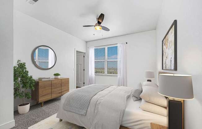 A bedroom with a bed, a ceiling fan, and a window with blinds at Andover Pointe Apartment Homes, La Vista, NE, 68138