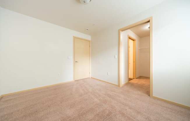 a bedroom with white walls and carpet