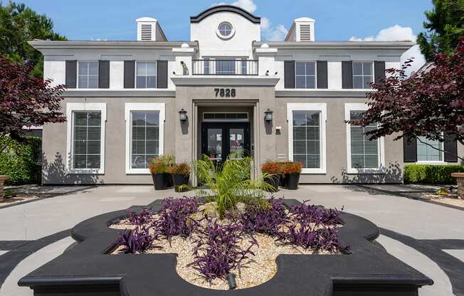 the front of a building with a garden in front of it