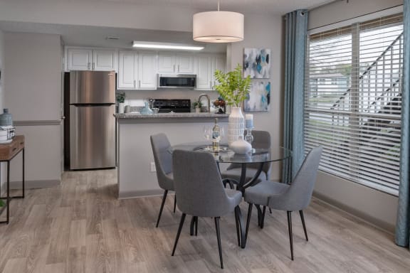 dining area by kitchen, hardwood-style flooring and massive window at Preserve at Cedar River Apartments, Florida
