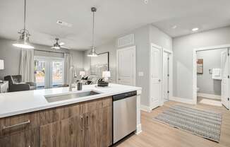 A modern kitchen with wooden cabinets and stainless steel appliances at The Ashton at East Park Apartments, Kennesaw, GA