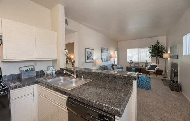 A kitchen with black countertops and white cabinets at Autumn Oaks Apartments, Roseville, CA, 95678