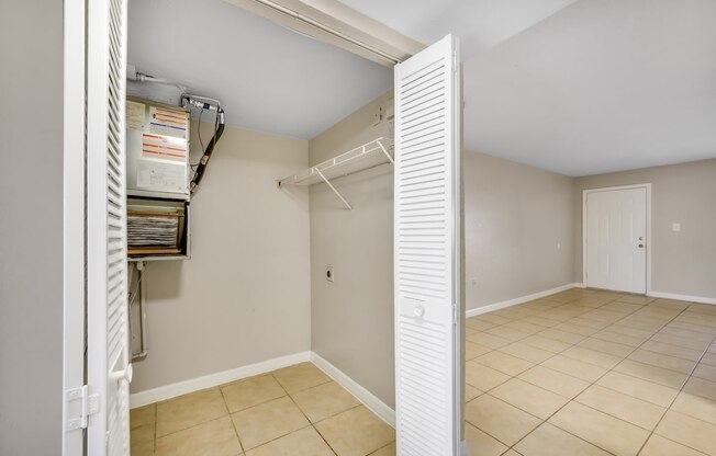 the closet in the bedroom of a home with a tiled floor