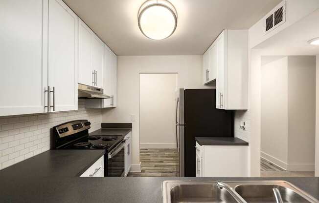 A kitchen with black countertops and white cabinets.