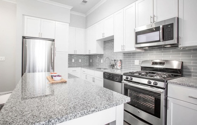 a kitchen with granite counter tops and stainless steel appliances
