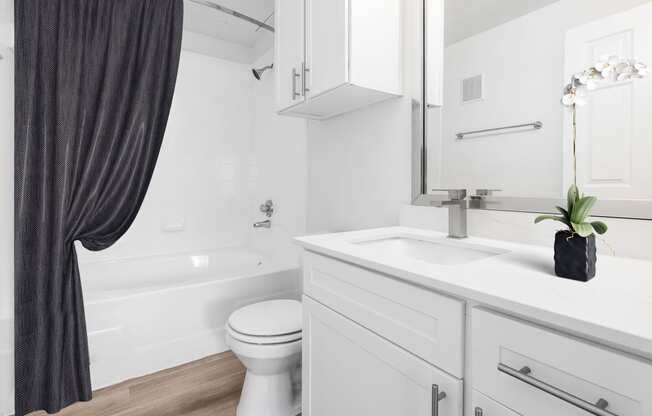 a bathroom with a white sink and toilet and a bath tub