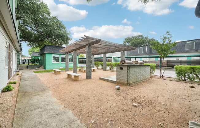 a picnic area with benches and a grill in front of a building