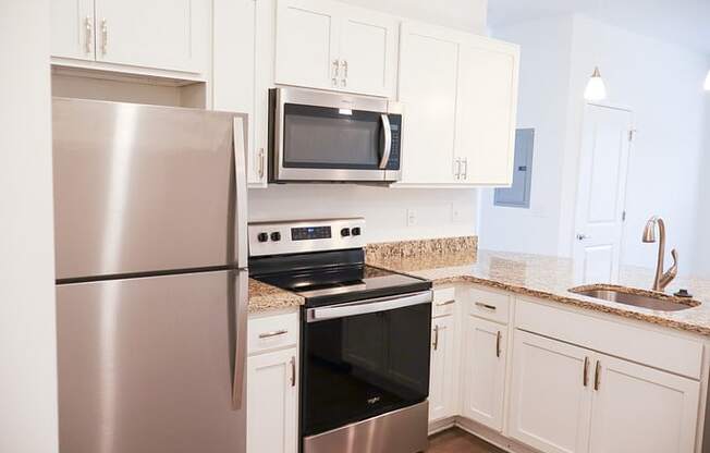 a kitchen with stainless steel appliances and white cabinets