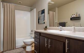 a bathroom with a white toilet next to a bathtub with a shower curtain