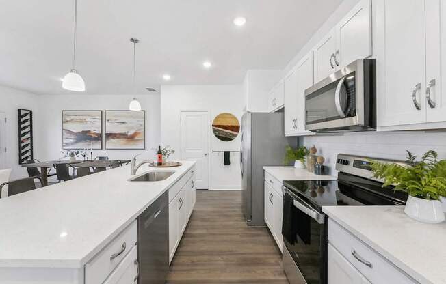 a large kitchen with white cabinets and stainless steel appliances