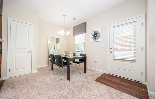 A room with a dining table and chairs.