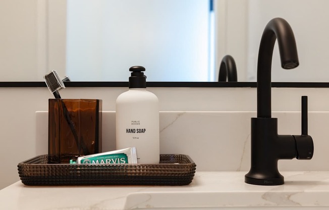 A white bottle of hand soap sits on a bathroom counter at Skylar At Sunset Apartments, Los Angeles