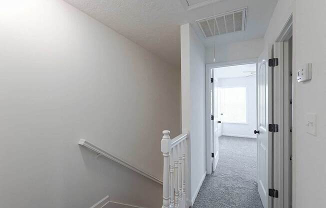 Carpet throughout the upstairs hallway leading into a bedroom
