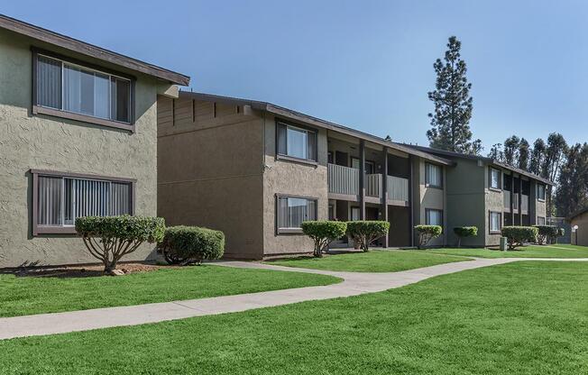 a house with a lawn in front of a brick building