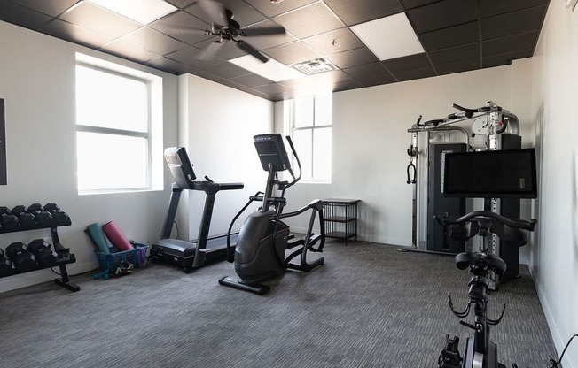 a home gym with exercise equipment and a tv