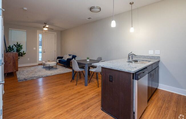 an empty living room with an open kitchen and dining area